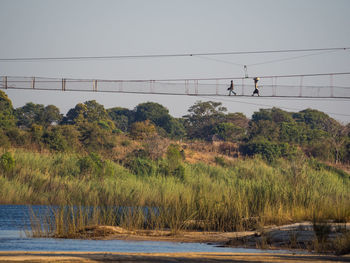 Scenic view of local people walking on foot bridge over zambezi river, zambia