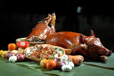 Close-up of roasted pork with ingredient on banana leaf