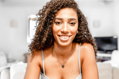 Portrait of smiling young woman sitting at home