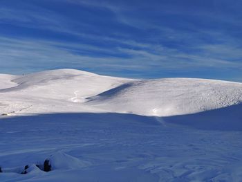 Scenic view of snow covered mountains against sky