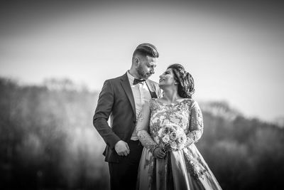 Couple holding hands while standing outdoors