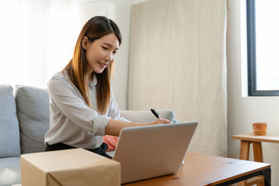 Young woman using laptop while sitting at home