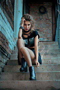 Portrait of young woman sitting on staircase