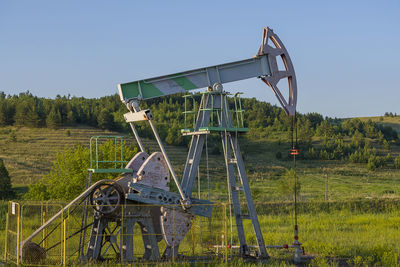 Traditional windmill on field against clear sky