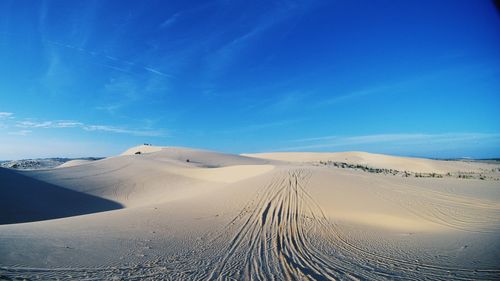 Scenic view of desert against clear blue sky