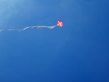 Low angle view of kite against clear blue sky