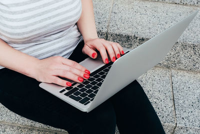 Midsection of woman using mobile phone