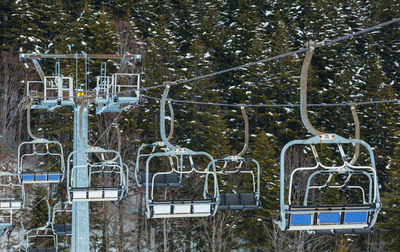 Chair lift on over the snowy forest at abetone, italy.