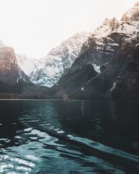 Scenic view of lake by snowcapped mountains against sky