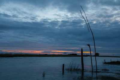 Scenic view of sea against cloudy sky at sunset