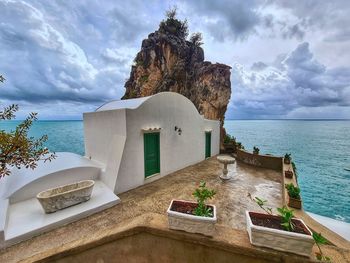 Built structure on beach against cloudy sky