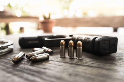 Close-up of handgun with bullets on table