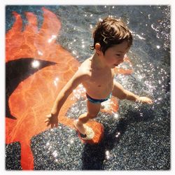 Full length of shirtless boy in water