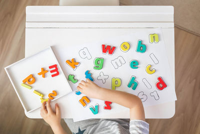 Cropped hands of woman holding book on table