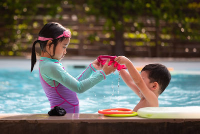 Siblings enjoying at swimming pool