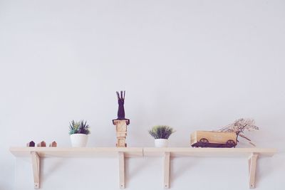 Table with flowers on shelf at home