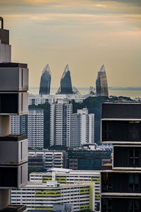 Modern buildings in city against sky during sunset