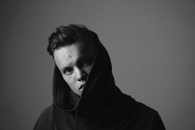 Portrait of young man against gray background