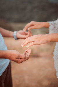 Midsection of couple holding hands