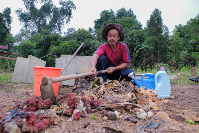 Portrait of smiling young woman sitting on land