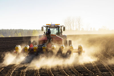 Tractor plowing field at sunny day