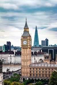 Buildings in city against cloudy sky