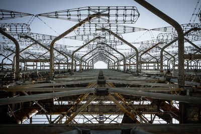 Low angle view of metallic built structure against sky