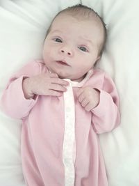 Cute baby girl lying on bed