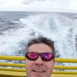 Portrait of man wearing sunglasses on boat sailing in sea