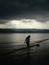 Rear view of man standing in sea