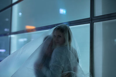 Portrait of young woman with friend covered in plastic