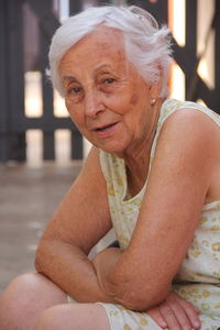 Portrait of senior woman sitting at yard