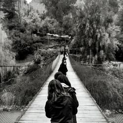 Rear view of woman walking on footbridge