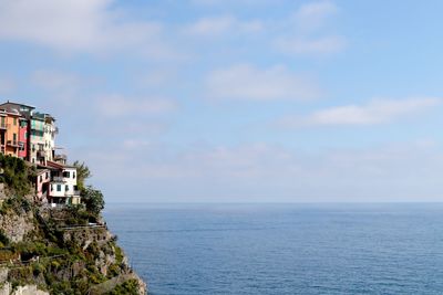 Scenic view of sea by buildings against sky