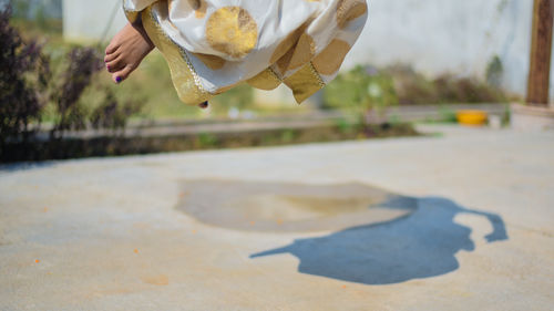 Low section of woman jumping on road