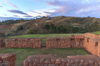 Built structure on landscape against the sky