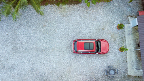 Top view of car parking on the land filled with aggregate stones.