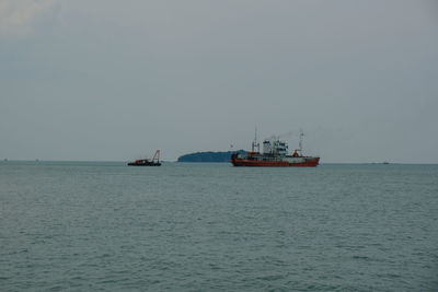 Boat sailing in sea against clear sky