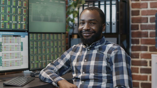 Portrait of young man standing in library