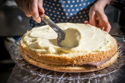 Midsection of woman making cake at home