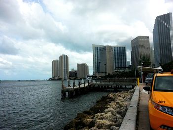 Buildings in city against cloudy sky