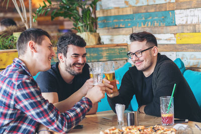 Happy friends sitting on table