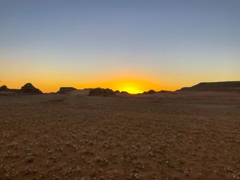 Scenic view of desert against sky during sunset