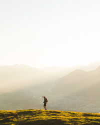 Man walking on mountain against clear sky