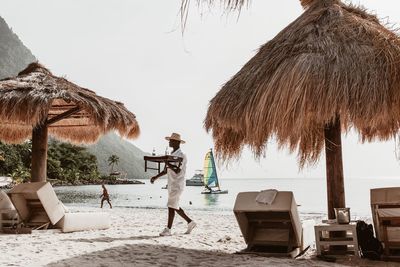 Panoramic view of people on beach against sky