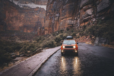 A car is on the rainy road in zion national park, utah