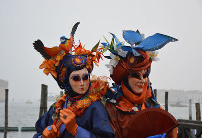 Full length of young woman with mask standing against clear sky