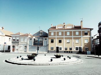 Buildings by street in city against sky