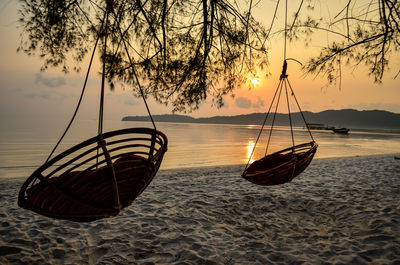 Boat on beach against sky during sunset