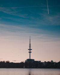 View of communications tower and buildings against sky